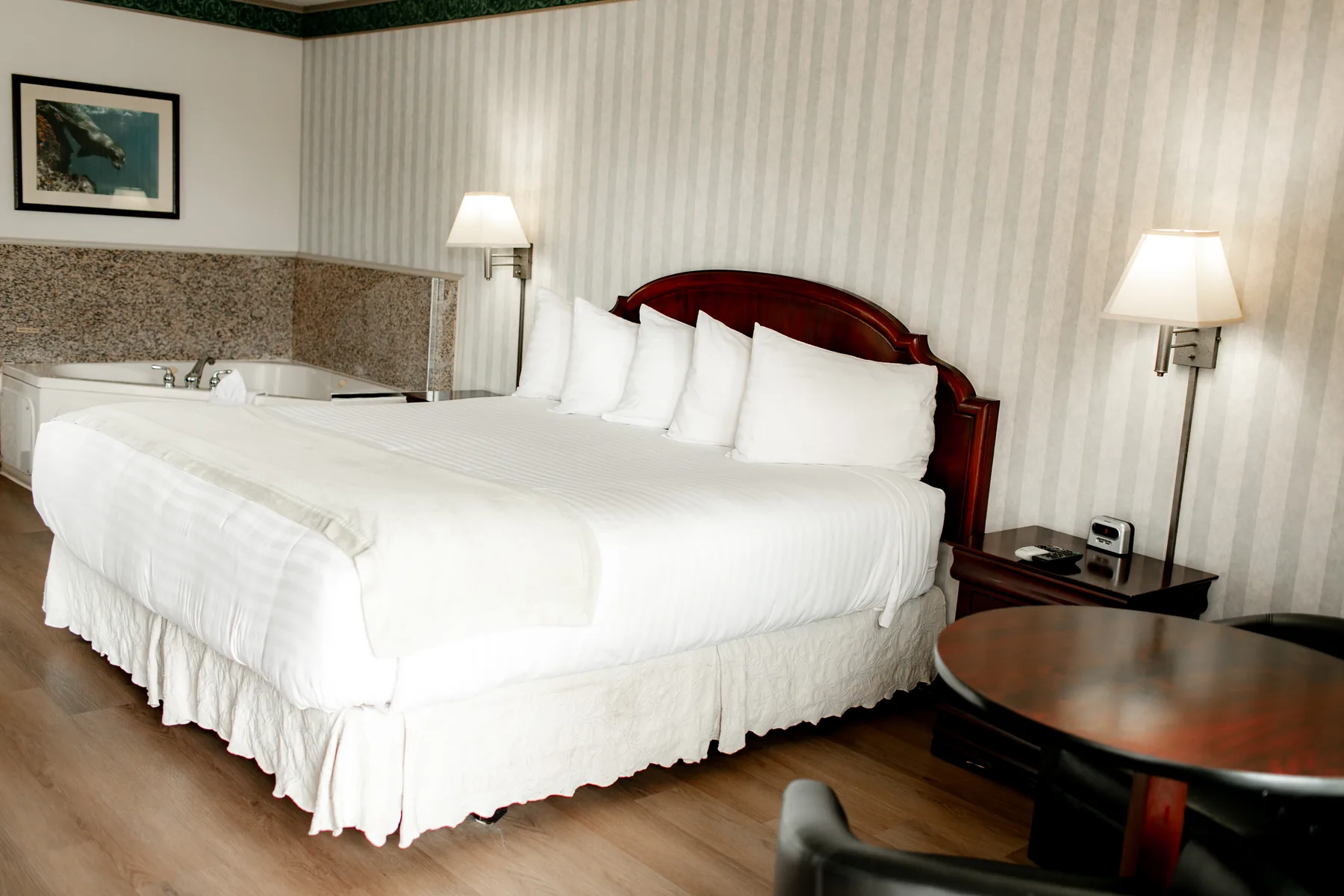 King bed room with table and striped wall covering