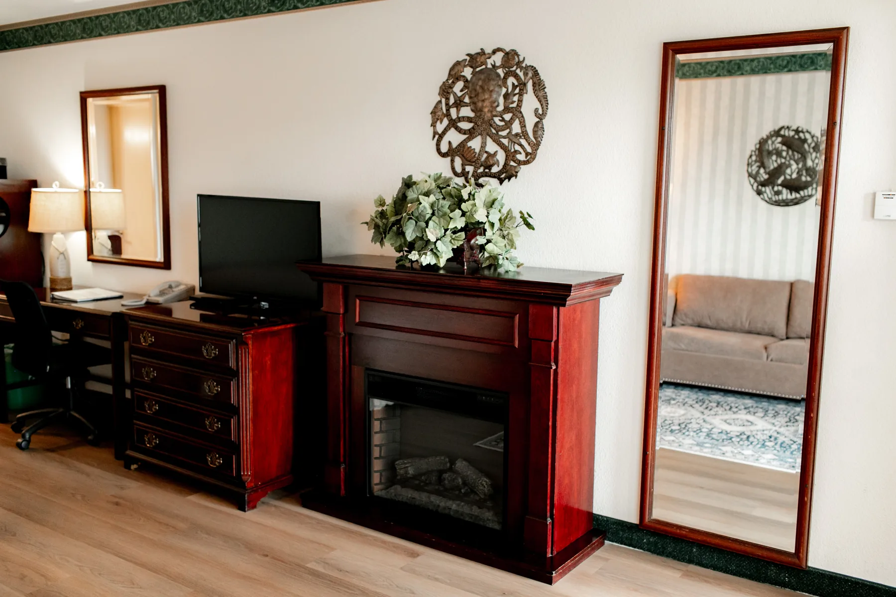 Dresser, fireplace, mirror, and TV in a suite