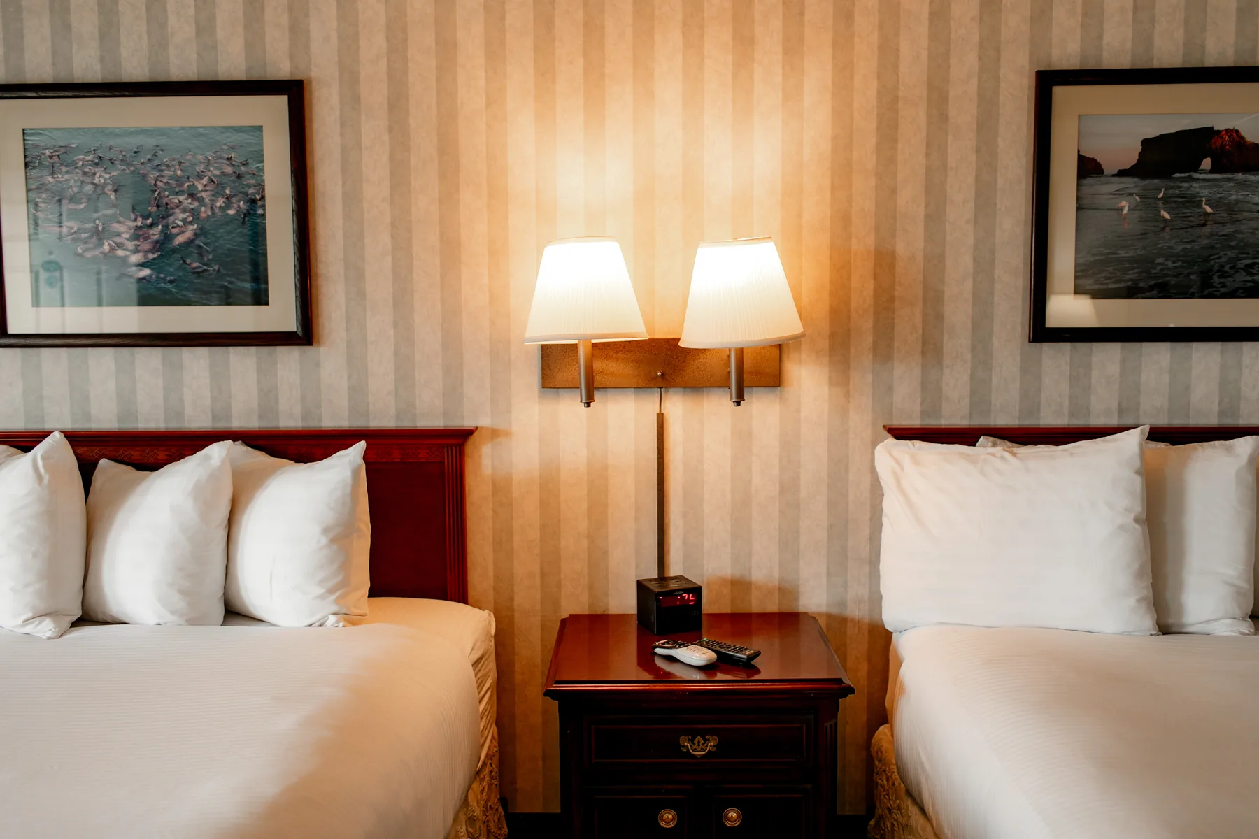 Two bed room with bedside table and wall art