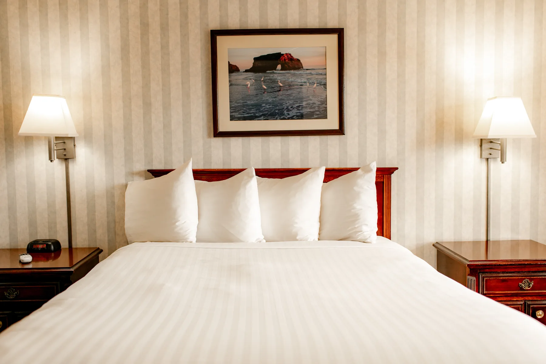 King bed centered between wall sconces