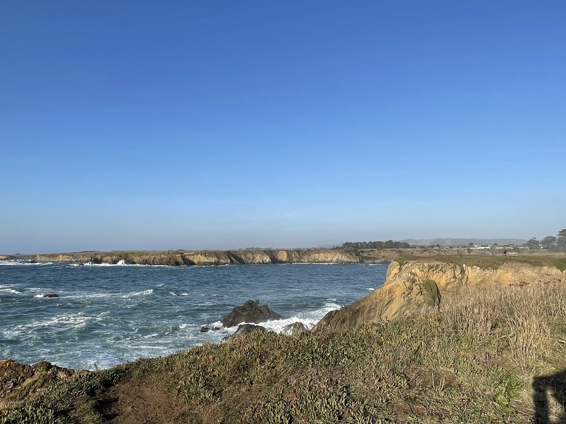 Ocean cliffs and blue water at Pomo Bluffs Park in Fort Bragg